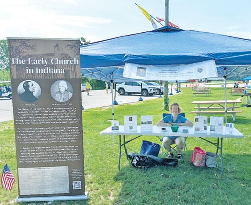 Archdiocesan archivist Julie Motyka staffs the Servant of God Bishop Simon Brut&eacute; exhibit on July 5 at the Catholic Saints of America celebration at the National Shrine of Our Lady of Champion in Champion, Wis. (Submitted photo)