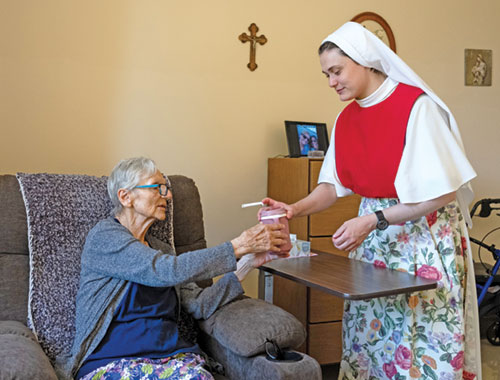 An undated file photo shows a Dominican Sister of Hawthorne serving a resident at Rosary Hill Home in Hawthorne, N.Y. On July 30, a judge temporarily shielded four orders of women religious and Catholic healthcare ministries from enforcement of a New York state law allowing physicians to aid terminally ill adults in dying by suicide. (OSV News photo/courtesy Becket)